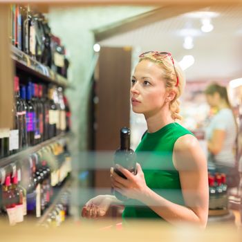 Beautiful caucasian woman shopping groceries at supermarket.