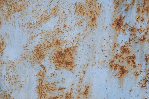 rusty iron surface covered with old chipped blue color paint, which has long been influenced by different climatic conditions