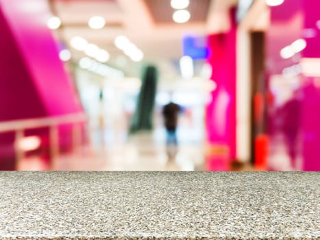 Marble board empty table in front of blurred background. Perspective marble table over blur in shopping mall hall. Mock up for display or montage your product.