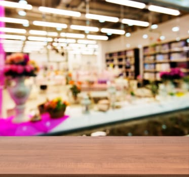 Wooden board empty table in front of blurred background. Perspective light wood table over blur in shopping mall hall. Mock up for display or montage your product.