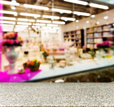 Marble board empty table in front of blurred background. Perspective marble table over blur in shopping mall hall. Mock up for display or montage your product.