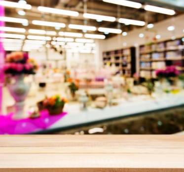 Wooden board empty table in front of blurred background. Perspective light wood table over blur in shopping mall hall. Mock up for display or montage your product.