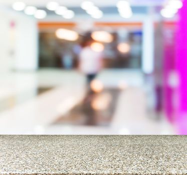 Marble board empty table in front of blurred background. Perspective marble table over blur in shopping mall hall. Mock up for display or montage your product.