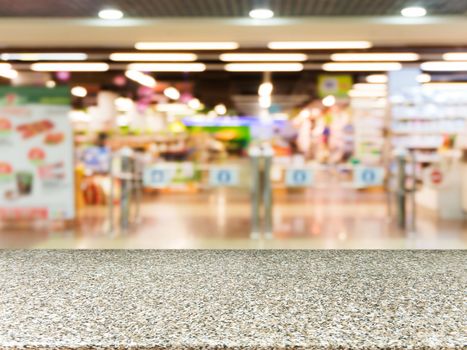 Marble board empty table in front of blurred background. Perspective marble over blur in entrance area of supermarket. Mock up for display or montage your product.