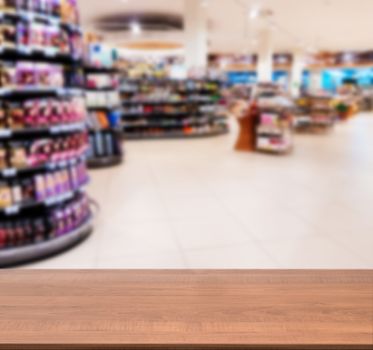 Wooden board empty table in front of blurred background. Perspective dark wood over blur in supermarket - can be used for display or montage your products. Mock up for display of product.