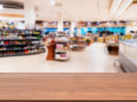 Wooden board empty table in front of blurred background. Perspective dark wood over blur in supermarket - can be used for display or montage your products. Mock up for display of product.