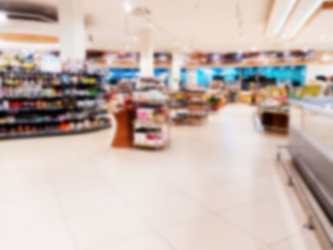 Abstract blurred supermarket aisle with colorful shelves and unrecognizable customers as background