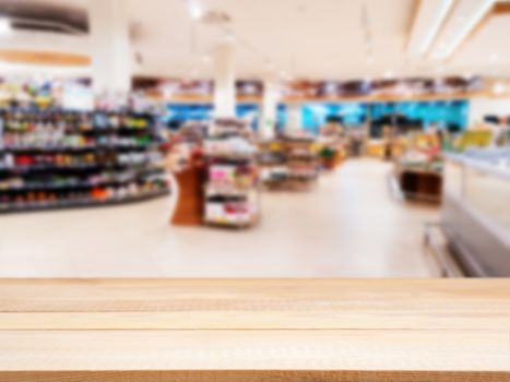 Wooden board empty table in front of blurred background. Perspective light wood over blur in supermarket - can be used for display or montage your products. Mock up for display of product.