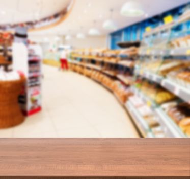 Wooden board empty table in front of blurred background. Perspective dark wood over blur in supermarket - can be used for display or montage your products. Mock up for display of product.