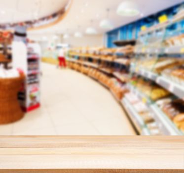 Wooden board empty table in front of blurred background. Perspective light wood over blur in supermarket - can be used for display or montage your products. Mock up for display of product.