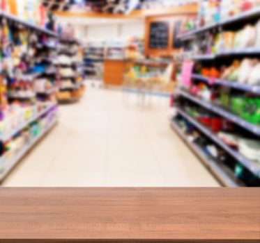 Wooden board empty table in front of blurred background. Perspective dark wood over blur in supermarket - can be used for display or montage your products. Mock up for display of product.