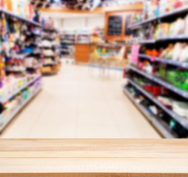 Wooden board empty table in front of blurred background. Perspective light wood over blur in supermarket - can be used for display or montage your products. Mock up for display of product.