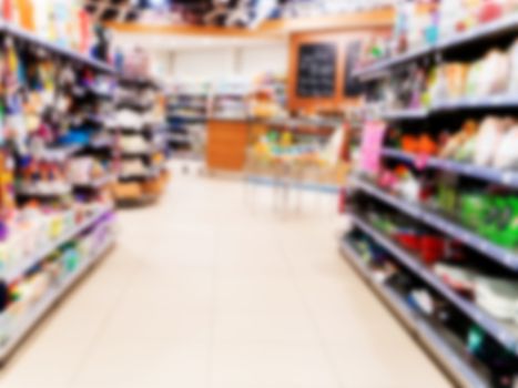 Abstract blurred supermarket aisle with colorful shelves and unrecognizable customers as background