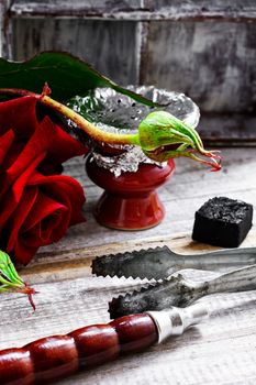 Smoking hookah filled with tobacco with the taste of roses