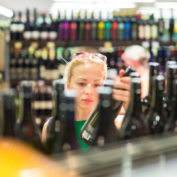 Beautiful caucasian woman shopping groceries at supermarket.