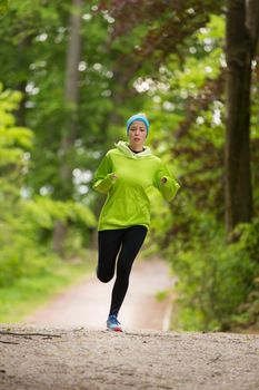 Sporty young female runner in forest.  Running woman. Female runner during outdoor workout in nature. Fitness model outdoors. Weight Loss. Healthy lifestyle. 