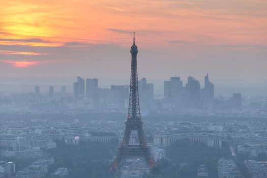 Aerial view of Paris with Eiffel tower and major business district of La Defence in background at sunset.
