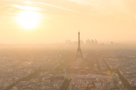 Aerial view of Paris with Eiffel tower and major business district of La Defence in background at sunset.