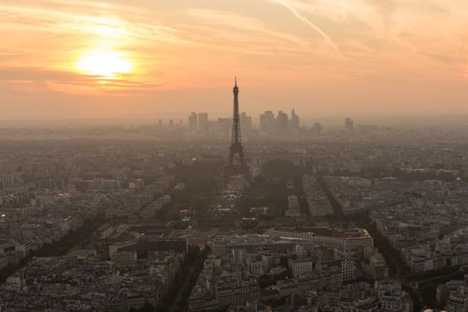Aerial view of Paris with Eiffel tower and major business district of La Defence in background at sunset.