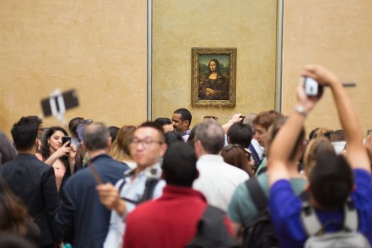 Paris, France - June 12: Crowd of visitors takes photos of Leonardo DaVinci's Mona Lisa, one of world's most famous work of art, at Louvre Museum on 12th of June ,2016 in Paris, France.