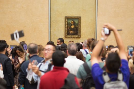 Paris, France - June 12: Crowd of visitors takes photos of Leonardo DaVinci's Mona Lisa, one of world's most famous work of art, at Louvre Museum on 12th of June ,2016 in Paris, France.