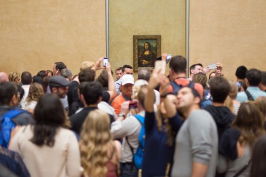 Paris, France - June 12: Crowd of visitors takes photos of Leonardo DaVinci's Mona Lisa, one of world's most famous work of art, at Louvre Museum on 12th of June ,2016 in Paris, France.