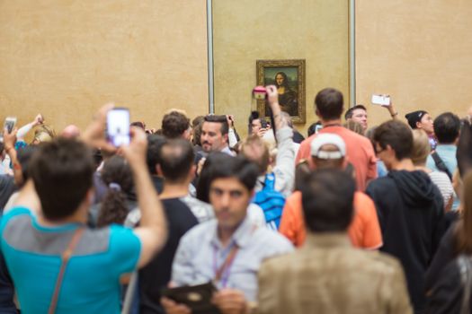 Paris, France - June 12: Crowd of visitors takes photos of Leonardo DaVinci's Mona Lisa, one of world's most famous work of art, at Louvre Museum on 12th of June ,2016 in Paris, France.