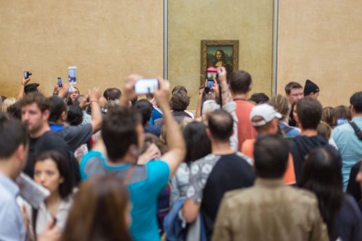 Paris, France - June 12: Crowd of visitors takes photos of Leonardo DaVinci's Mona Lisa, one of world's most famous work of art, at Louvre Museum on 12th of June ,2016 in Paris, France.