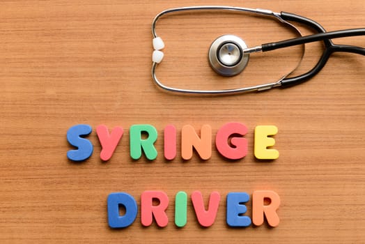 Syringe driver colorful word on the wooden background