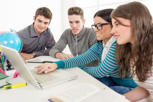 Four beautiful students of Geography sitting with laptop and learning.