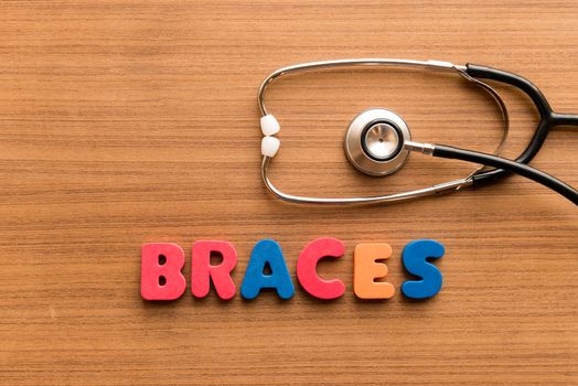 braces colorful word on the wooden background with stethoscope