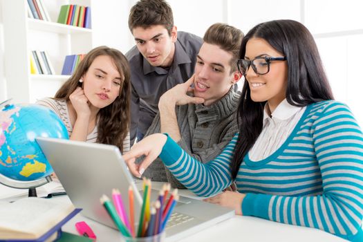 Four beautiful students of Geography sitting with laptop and learning.