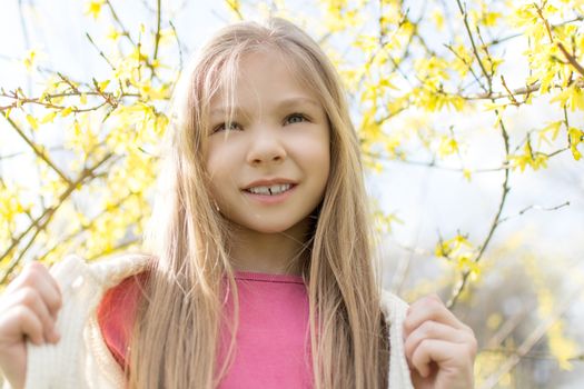Beautiful little girl in the park in spring.