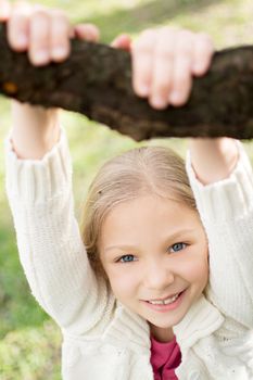 Beautiful funy little girl in the park in spring. Looking at camera.