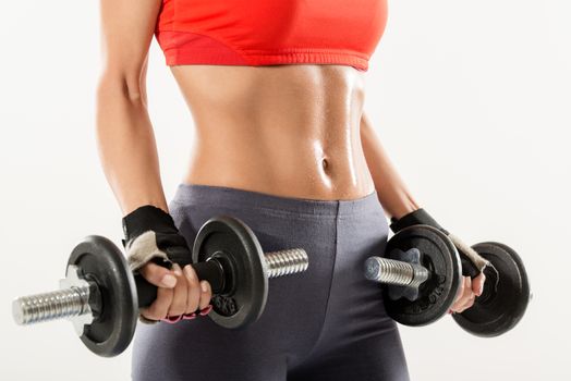 Close-up of the perfect woman body with dumbbells