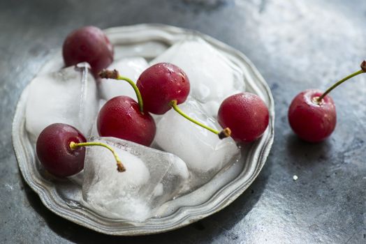 Delicious red sweet cherries with ice cubes