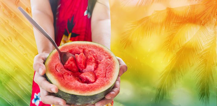 Women in easy red summer dress hand show  or present or giving fresh half watermelon on cheerful orange colour summer background