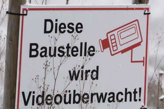 Construction sign with caption in German "This construction is Video Monitored"