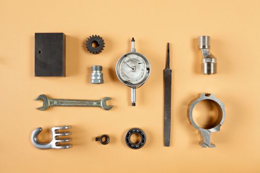 Mixture of different pieces of tools and machinery on orange background