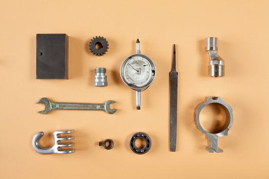 Mixture of different pieces of tools and machinery on orange background