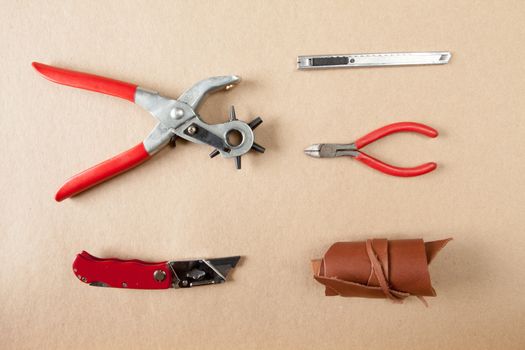 Working tools for embossed leather on brown background top view