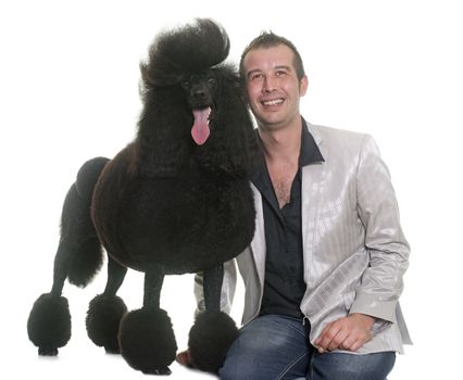 man and standard poodle in front of white background