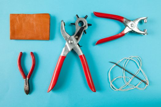 Working tools for embossed leather on blue background top view