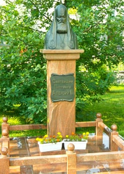 monument to the Patriarch Alexy 2 on the background of trees