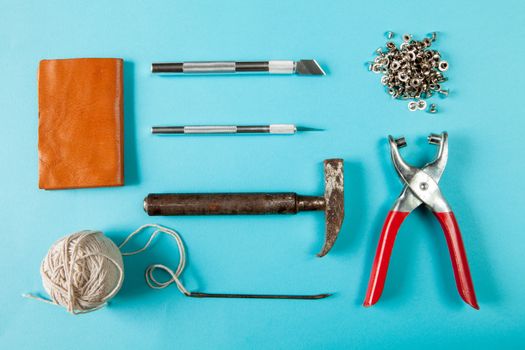 Working tools for embossed leather on blue background top view