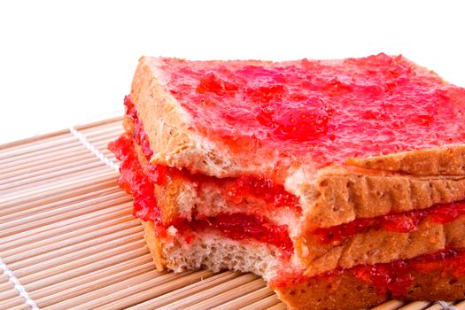 Whole wheat bread with strawberry jam on mat