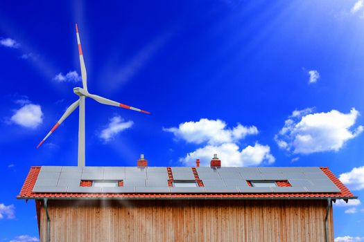 Solar panels and wind turbine against a sunny sky.