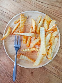 Traditional French fries on wood background.