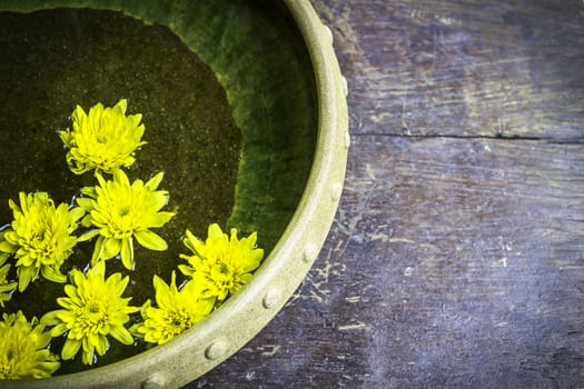 Spa therapy with yellow flowers on  water in bowl