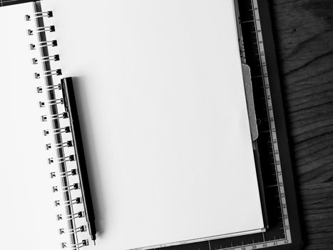 Blank notebook with pen on the table. black and white image.